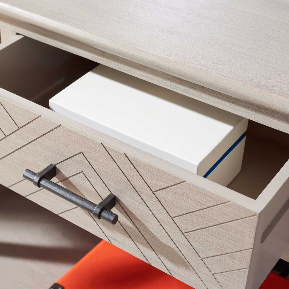 An open geometric drawer fits a small storage box beneath the greige console's lightly grained wood top