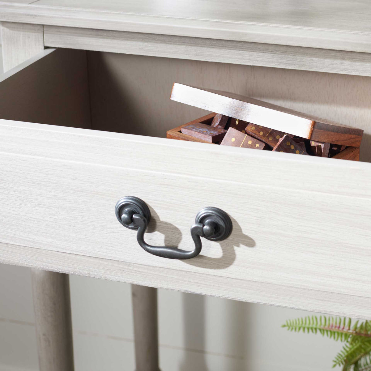 An open greige drawer offers discreet storage with a traditional dark metal pull.