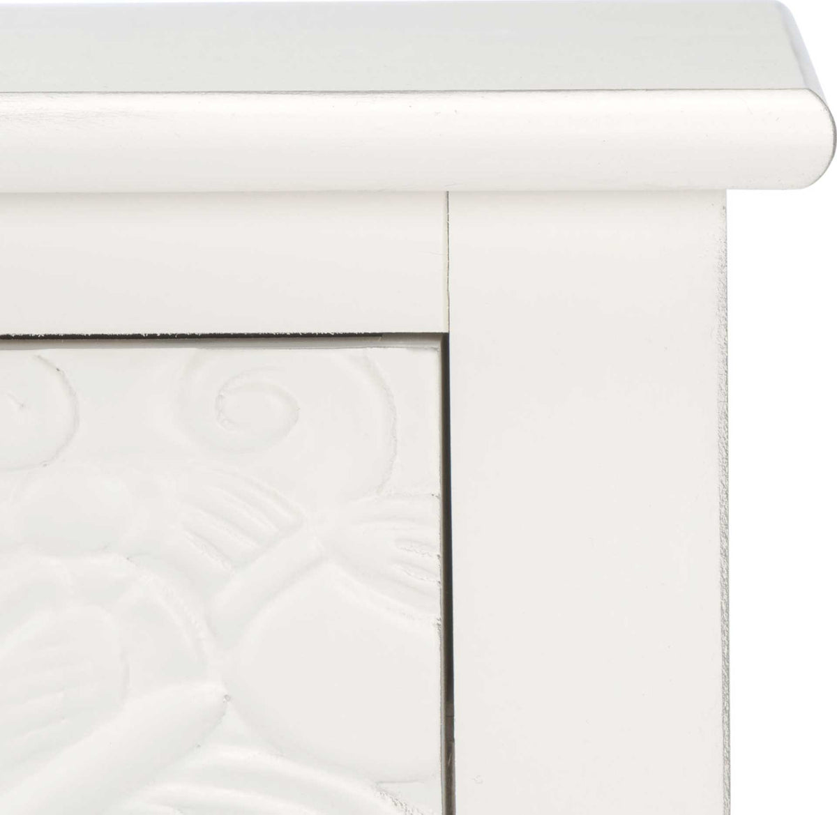 Softly distressed white finish and rounded tabletop edging frame the raised floral drawer design.