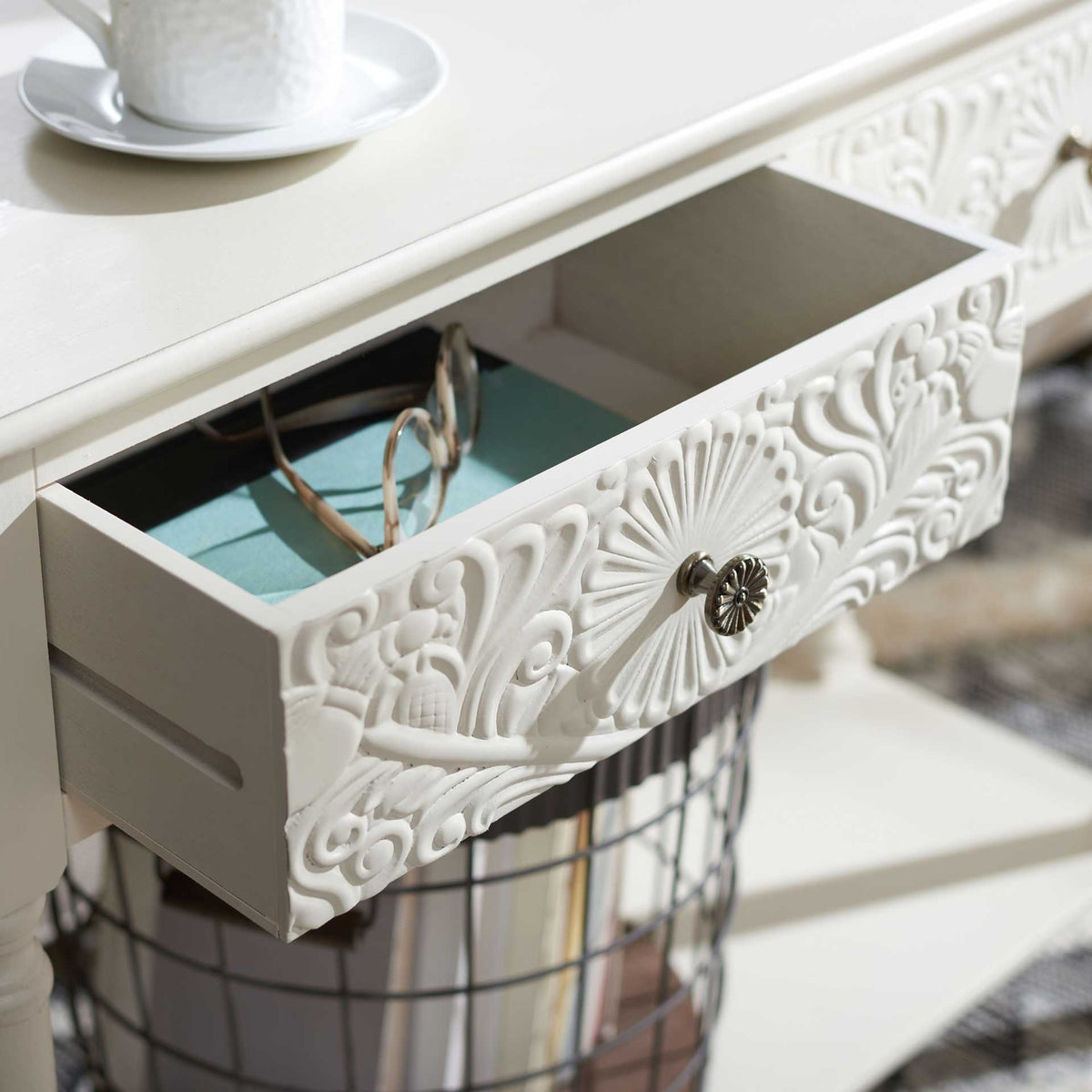 A floral-carved drawer opens wide for glasses and small belongings, with a decorative metal knob in front.