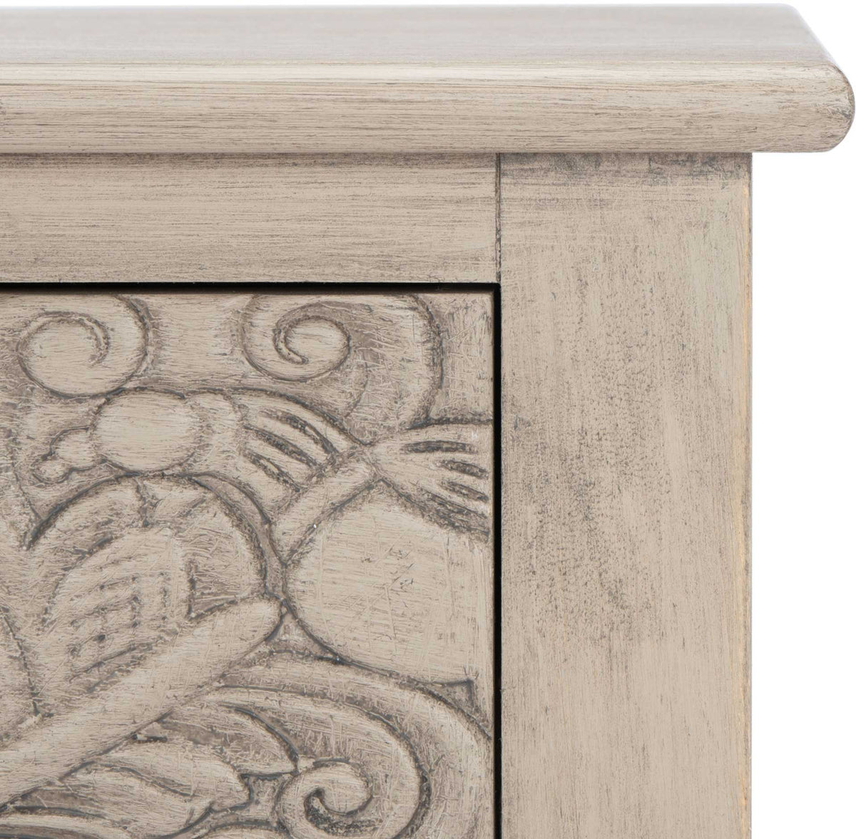 Soft greige wood grain and a weathered finish add depth to sculpted floral drawer detailing.