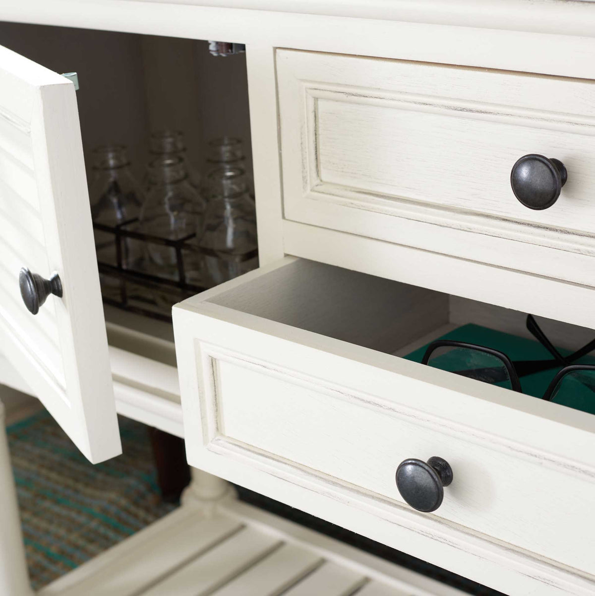 A pulled-out drawer and open cabinet door provide accessible storage in the white console.