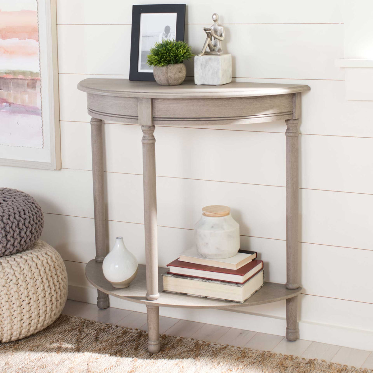 The greige console pairs a curved display top with a lower shelf for books and decor.