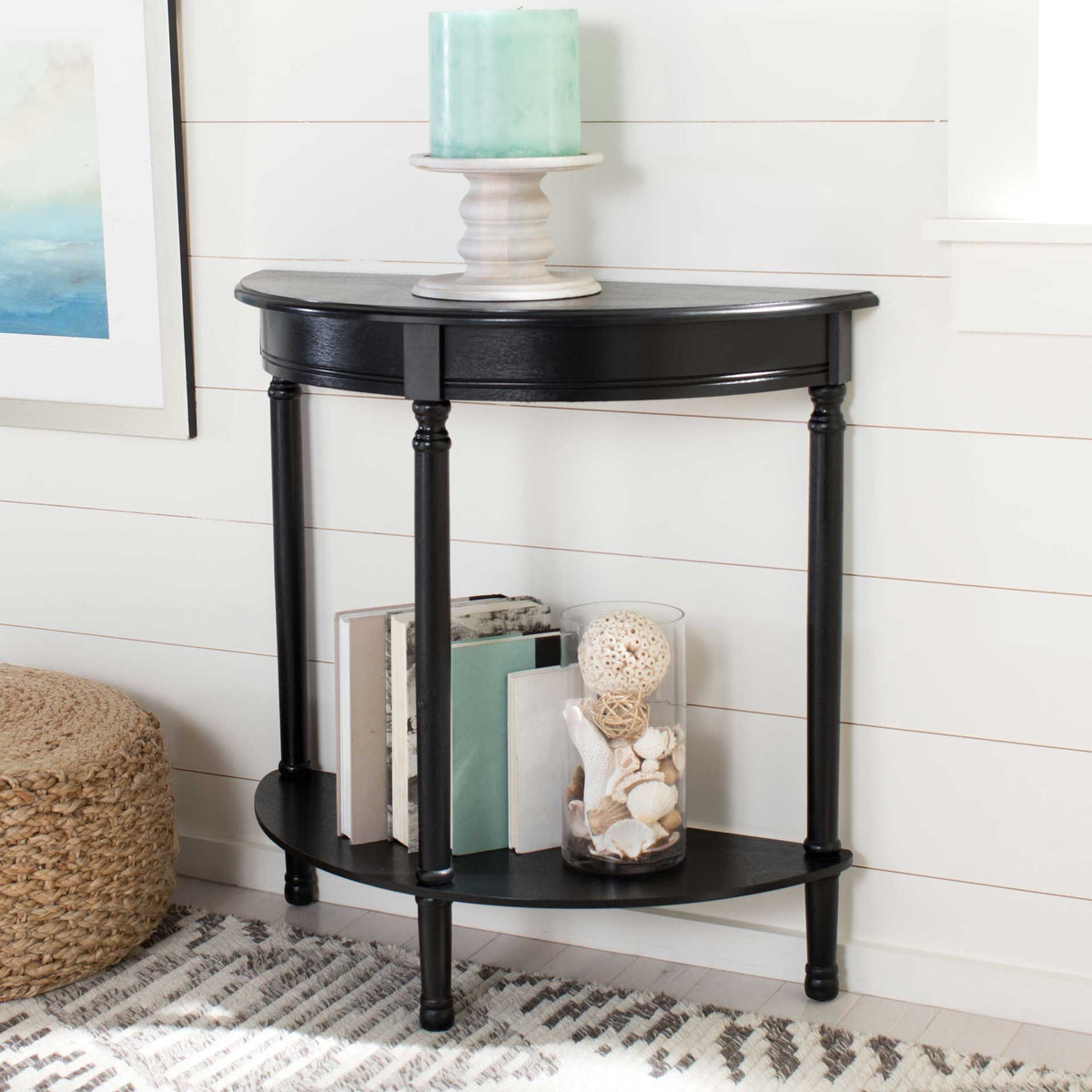 The black console displays decor on its curved top and books on its lower shelf.