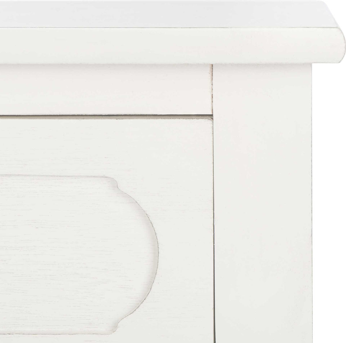 Subtle distressing traces the molded top edge and curved detailing of the white drawer front.