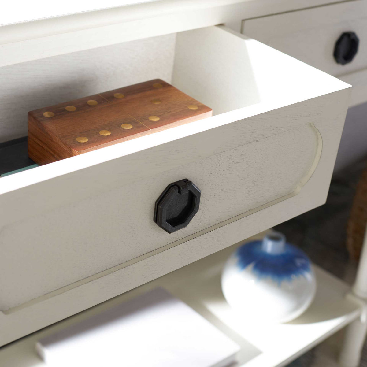 Open white drawer provides discreet storage, with a dark geometric ring pull on its shaped front.