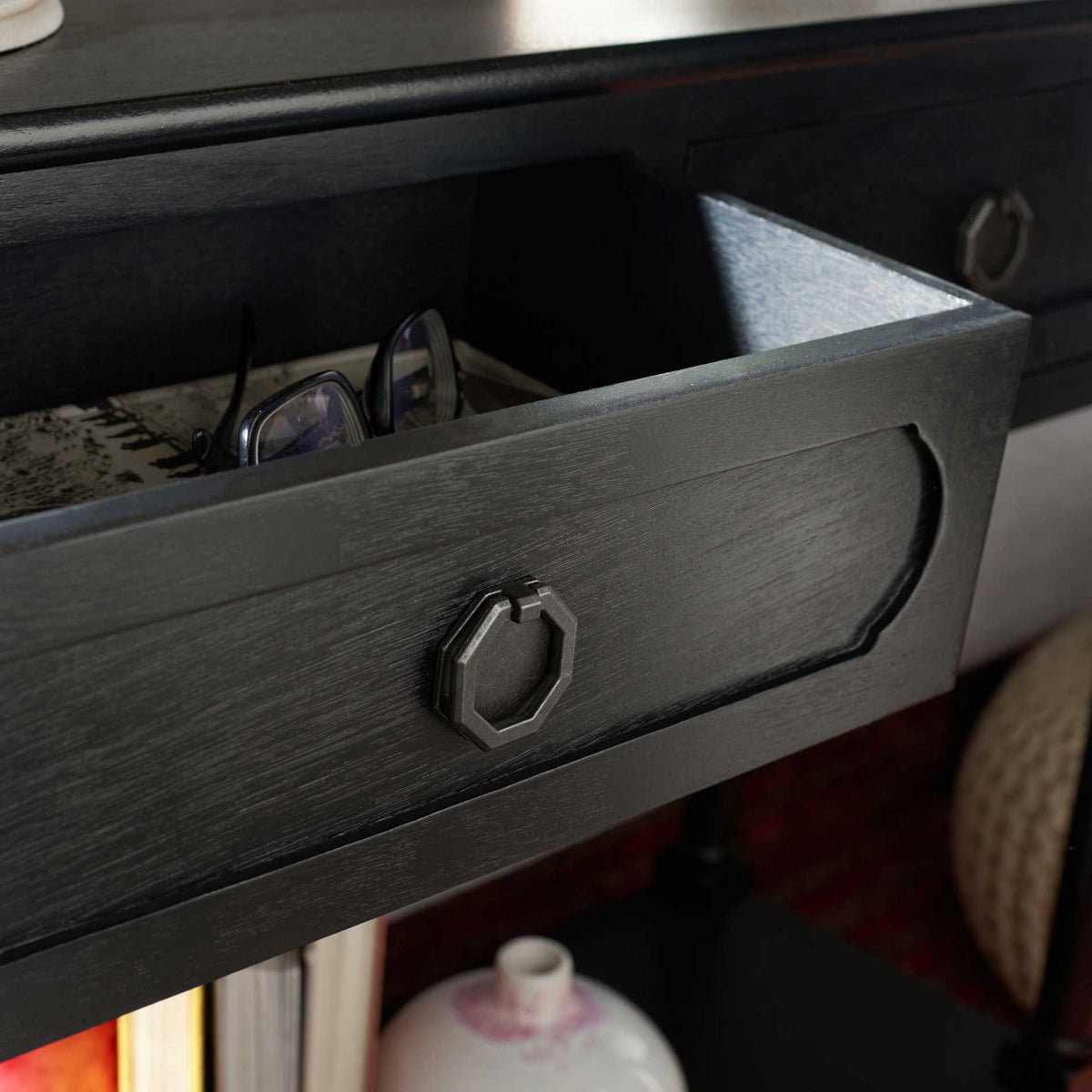Open black drawer keeps everyday essentials close behind a shaped front with an octagonal pull.