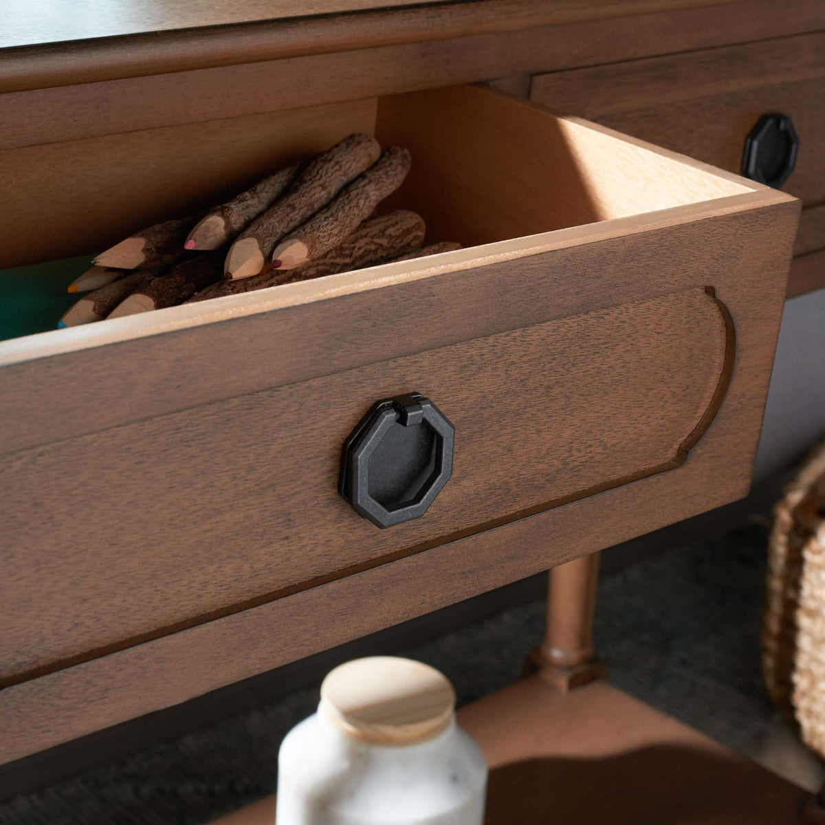 Open brown drawer offers handy storage for small items beneath its dark octagonal ring pull.