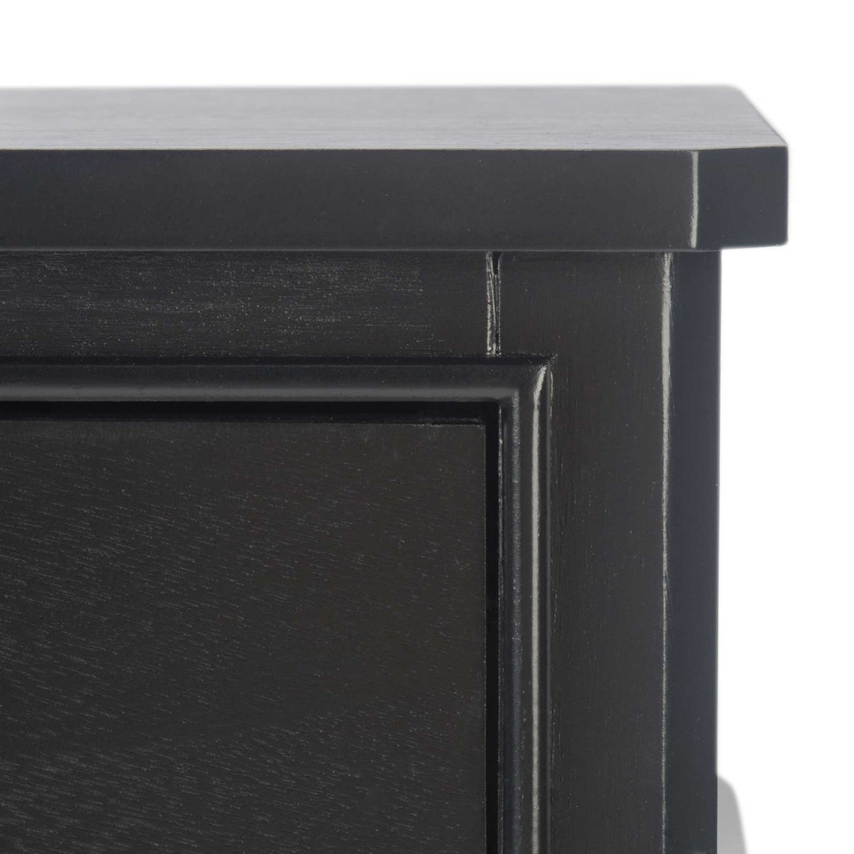 A slim black tabletop overhangs framed drawer trim with subtle wood grain