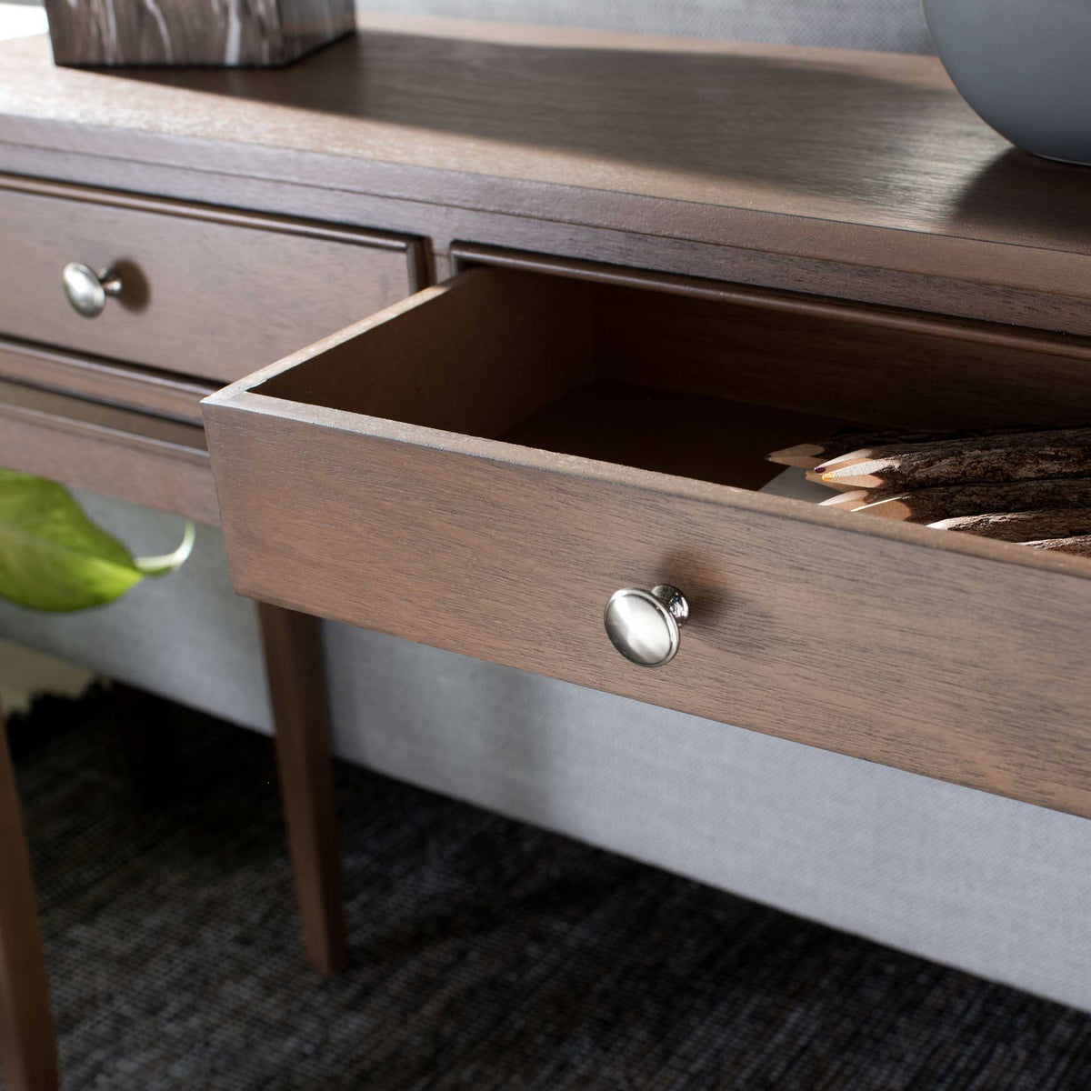 A warm brown drawer opens beneath a wood-grain tabletop for easy access to small essentials