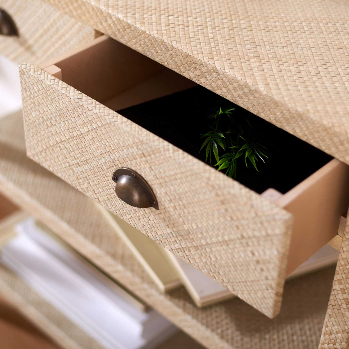 A woven drawer opens to reveal storage beneath the console's textured top