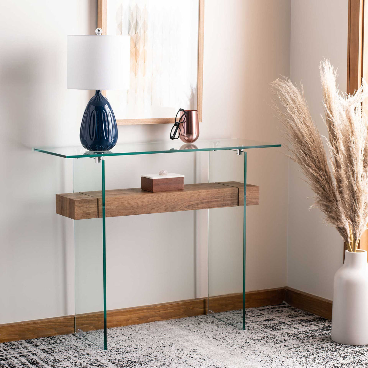 A warm brown shelf grounds this clear glass console in a comfortable, styled space.