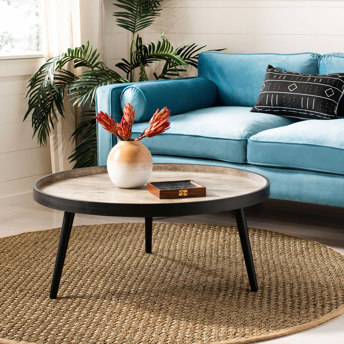 A two-tone coffee table pairs a pale gray tray top with black tapered legs