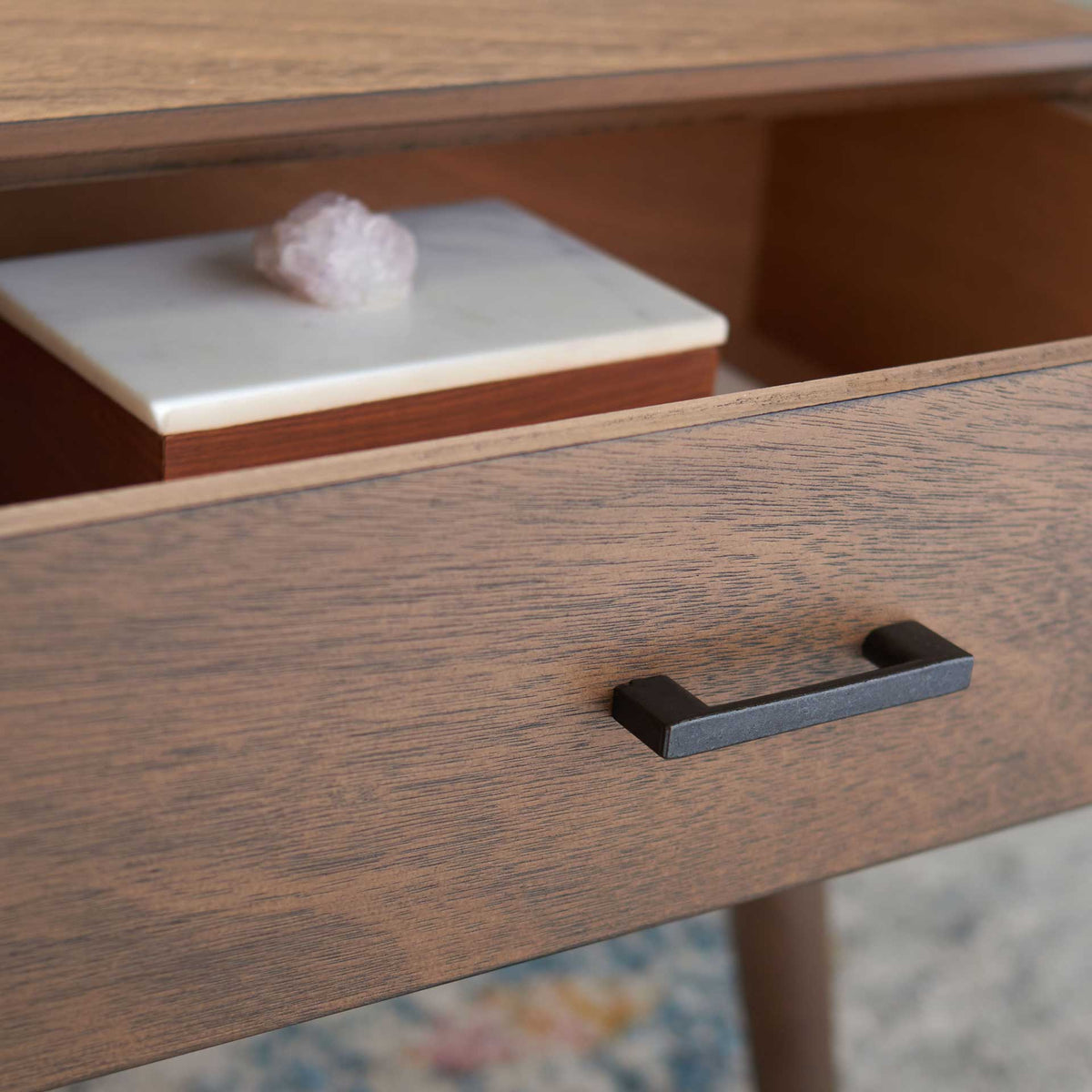 A generous drawer keeps small essentials tucked away behind a textured brown front.