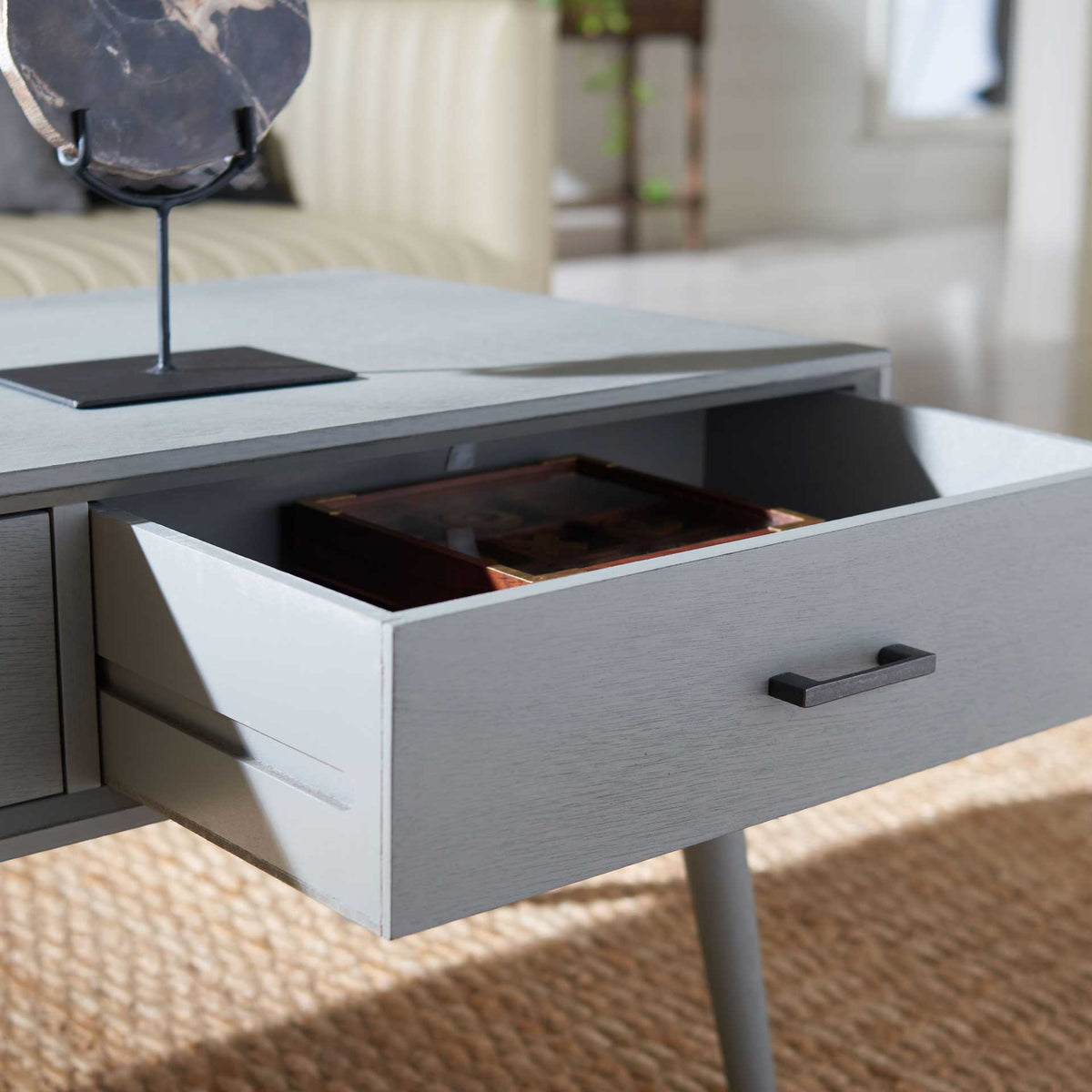 An open gray drawer offers generous storage for living room essentials.