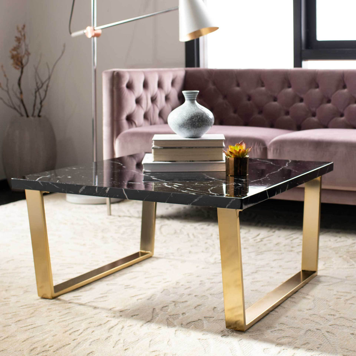 A black marble-look surface and gleaming brass-finished legs bring bold contrast to a living room.
