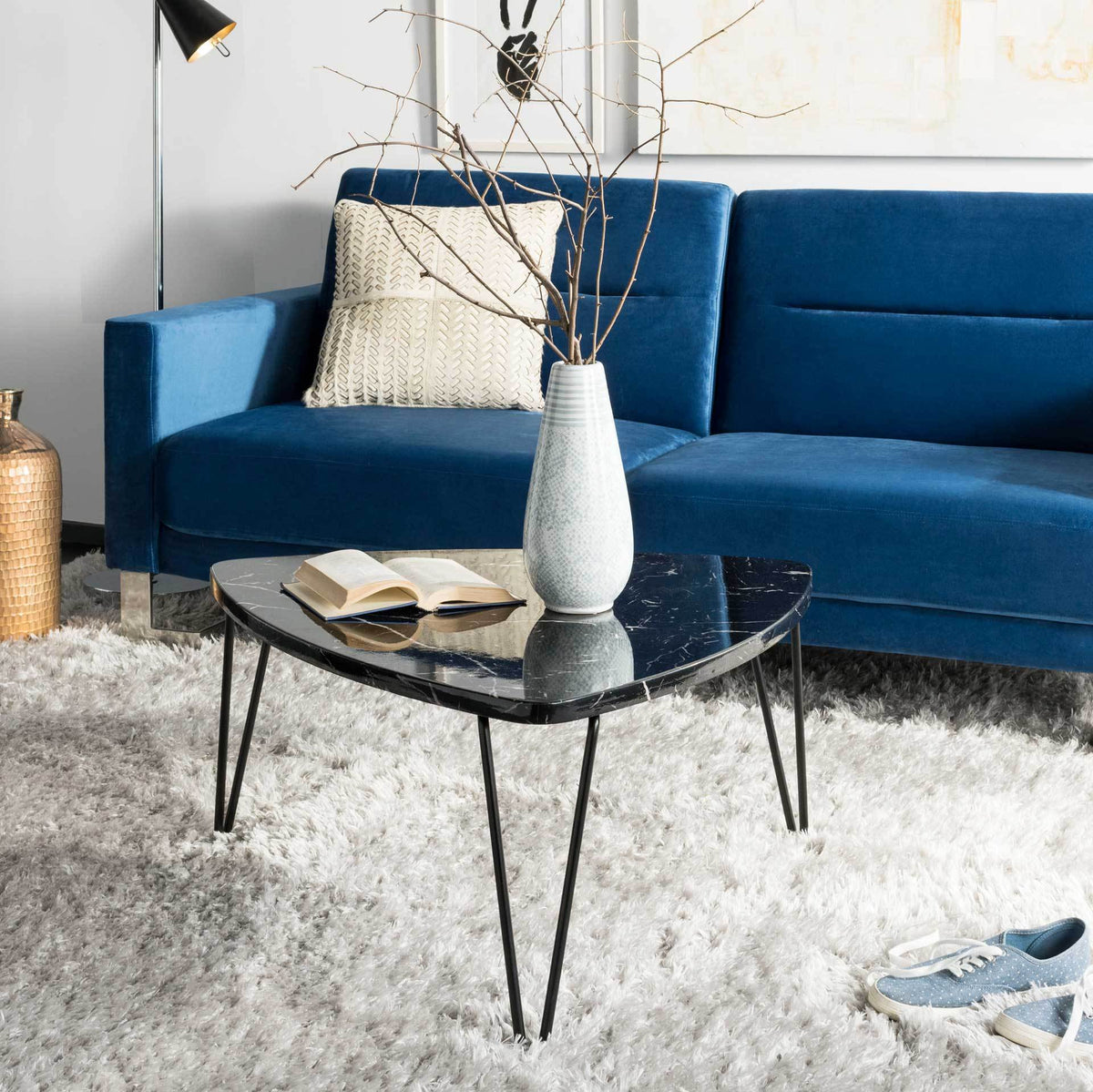 A glossy black marble-look coffee table adds sculptural style to a cozy seating area