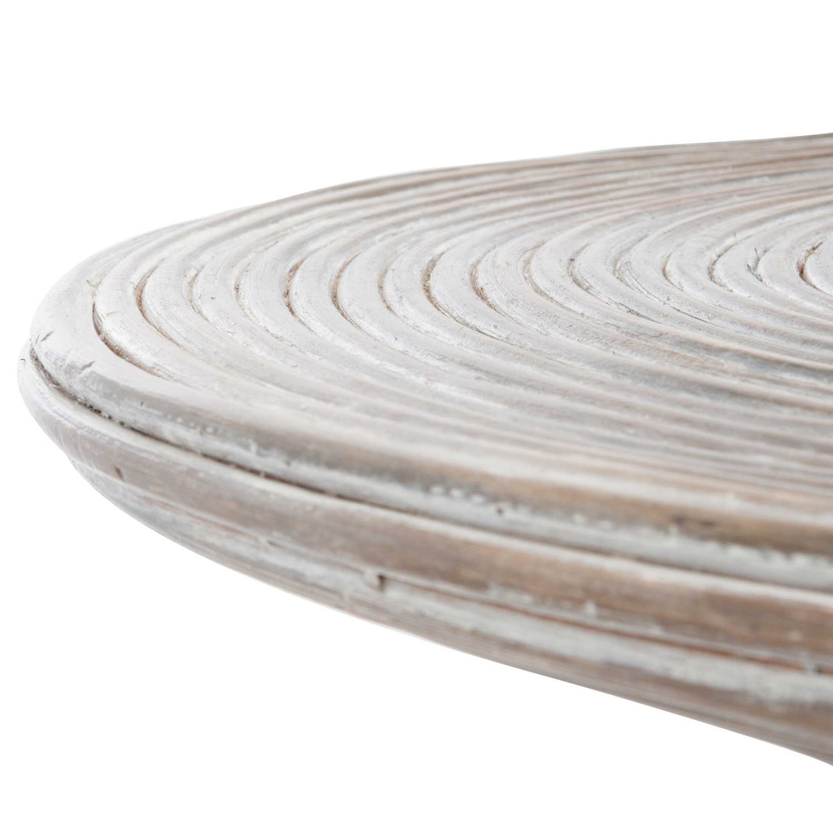 Layered circular grooves reach the softly rounded edge of the whitewashed tabletop.