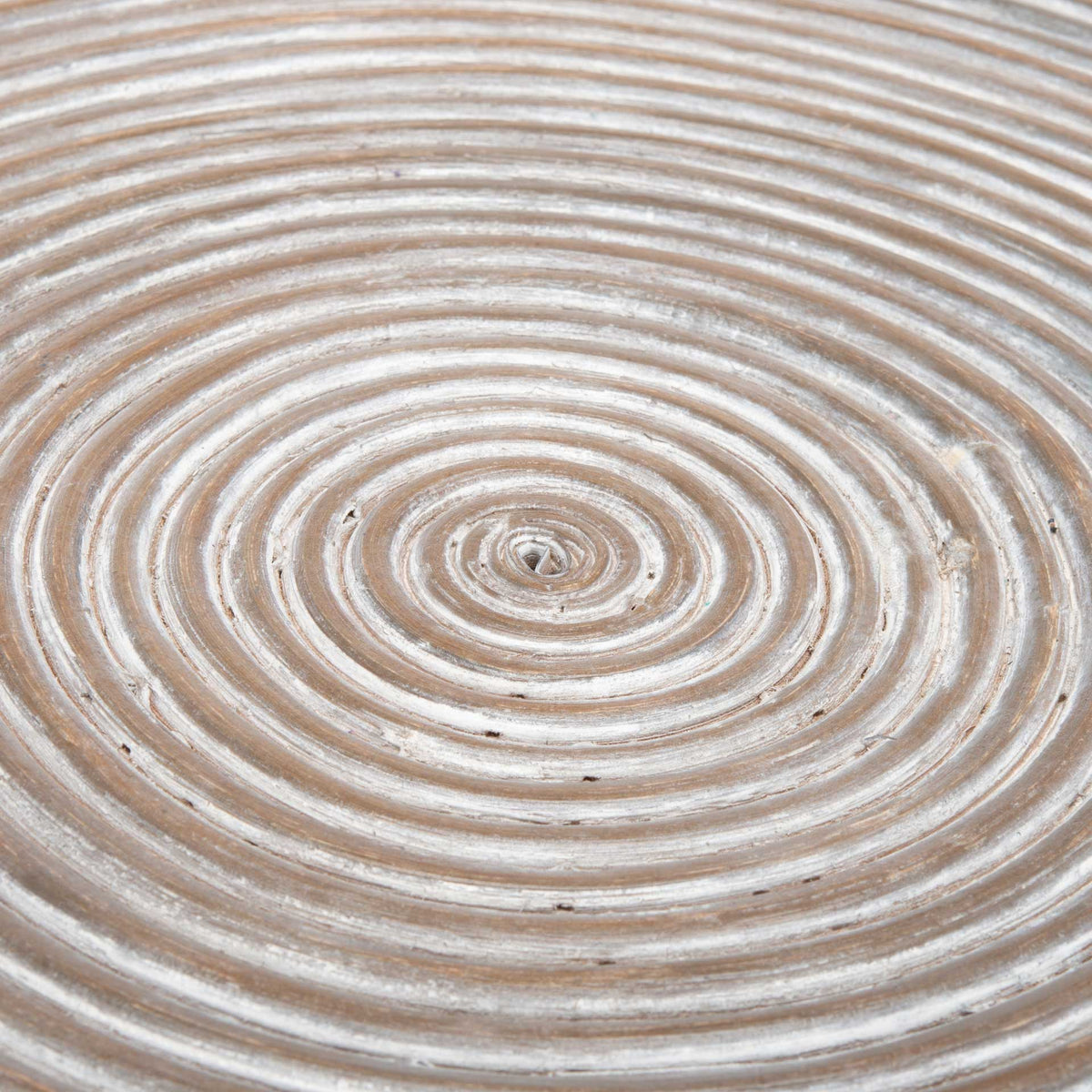 Concentric rings create a spiral pattern across the whitewashed gray tabletop.