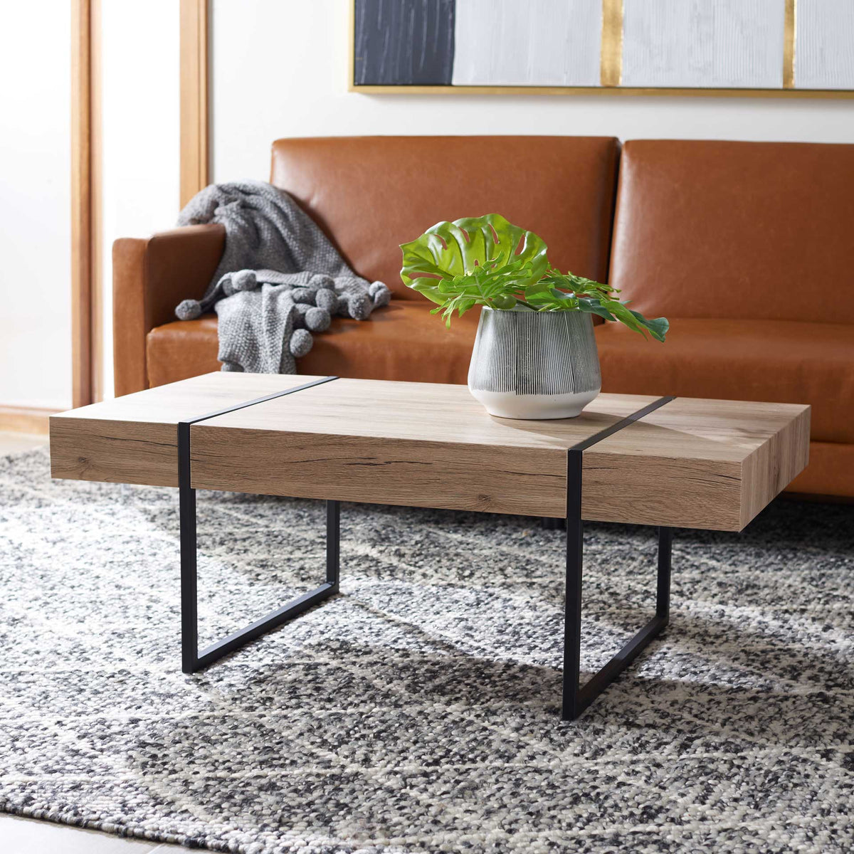 Warm wood grain and an airy black metal base add clean-lined style to a welcoming living room.