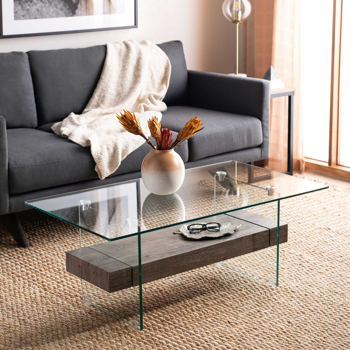 A light gray wood-look shelf adds understated texture to this airy glass coffee table