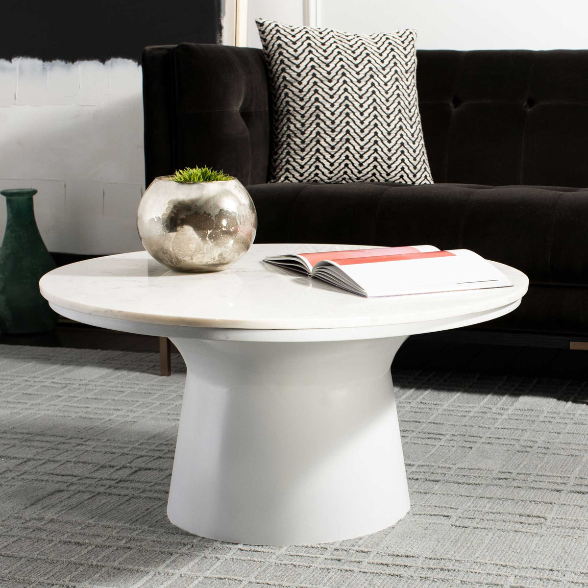A round marble top and curved white pedestal bring understated elegance to the living room