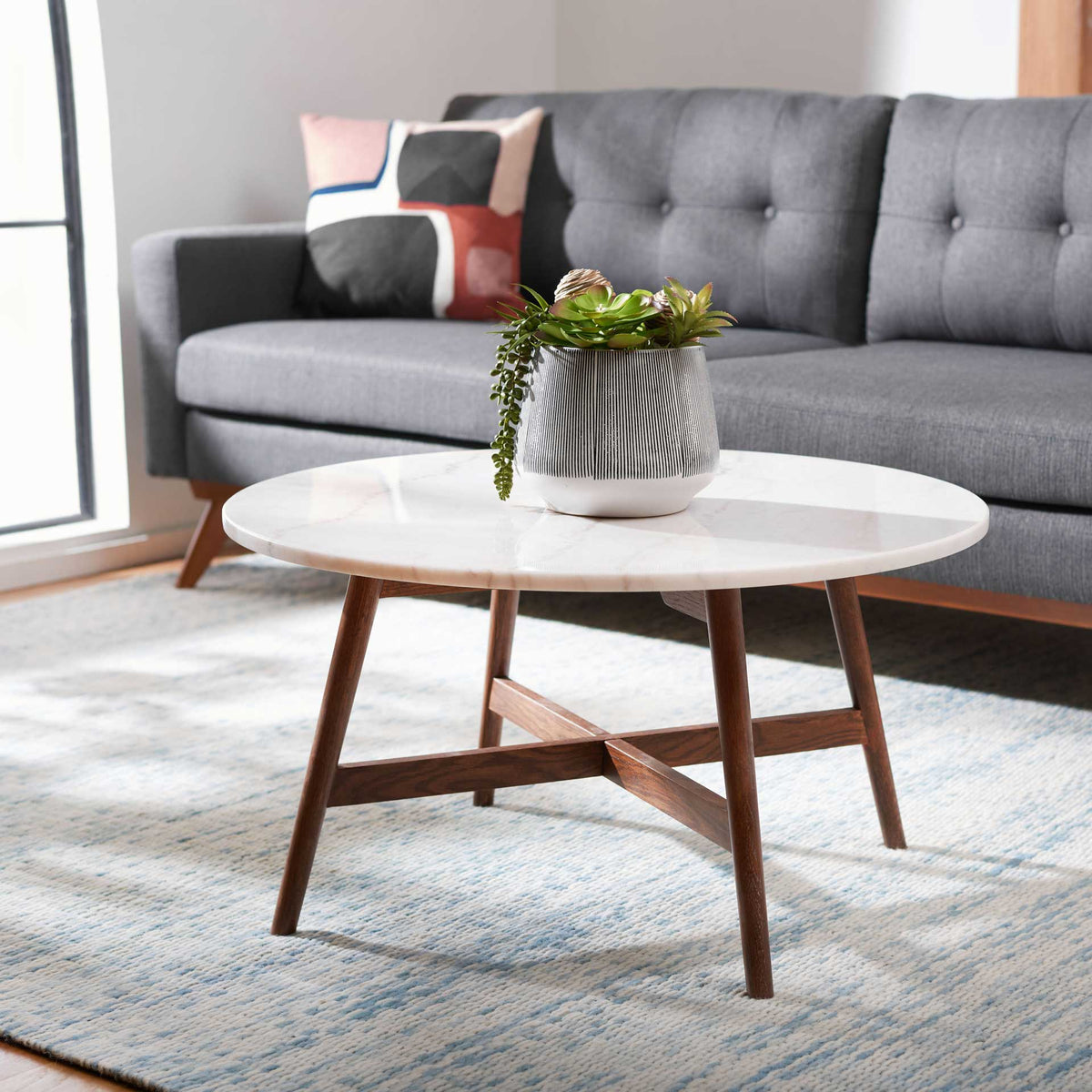 White marble and walnut-finished wood lend mid-century style to this round coffee table