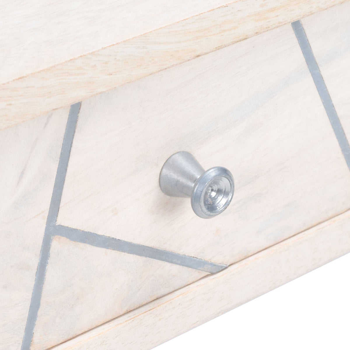 A silver knob punctuates angular silver inlay on the softly whitewashed wood drawer