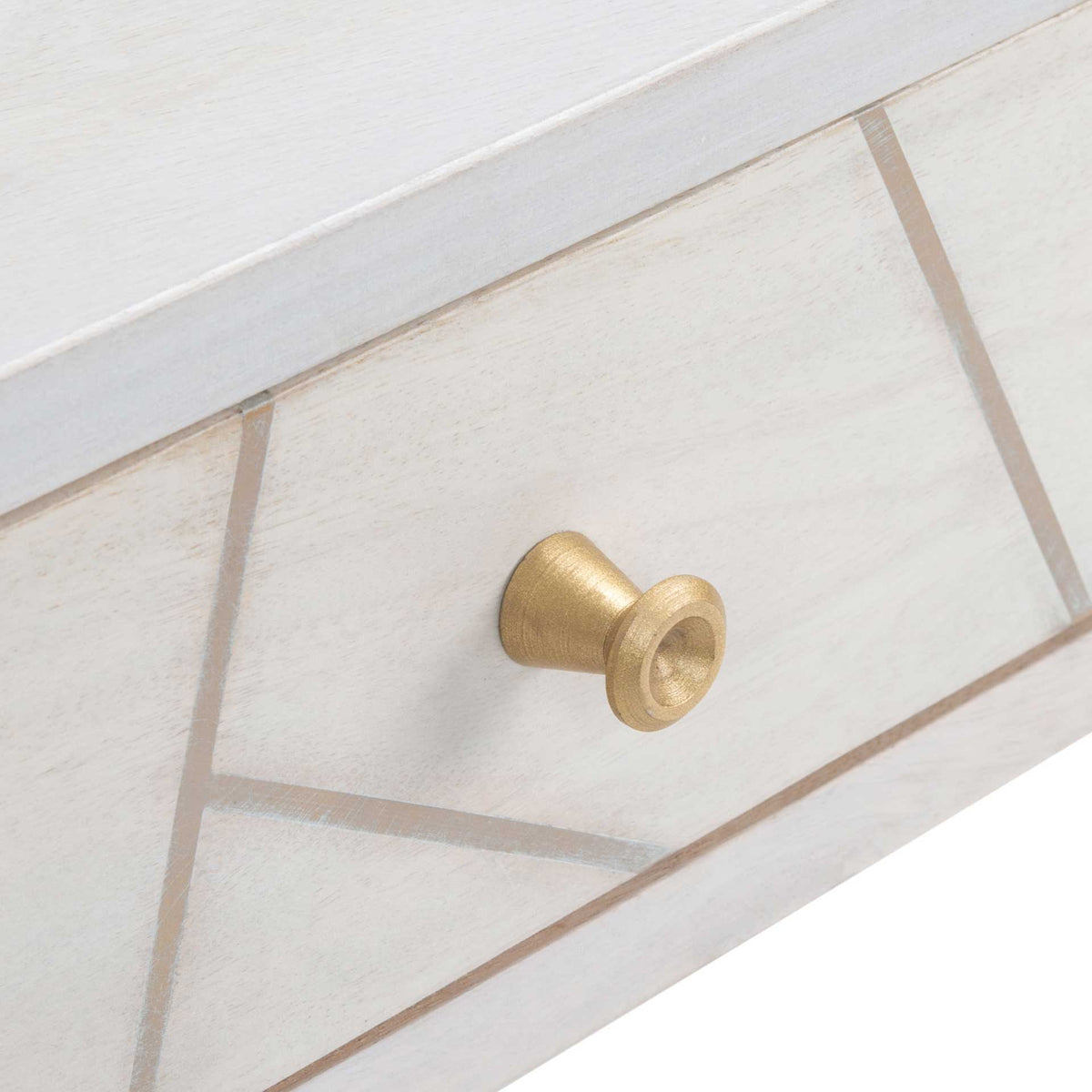 A warm brass knob accents the geometric inlay across the whitewashed wood drawer