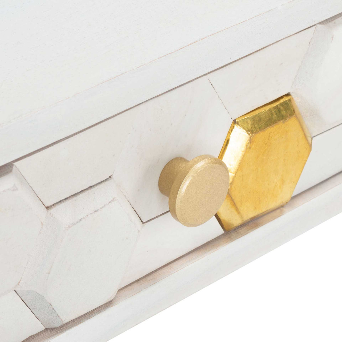 A round brass-tone knob sits among raised honeycomb carvings and a gleaming gold hexagon.