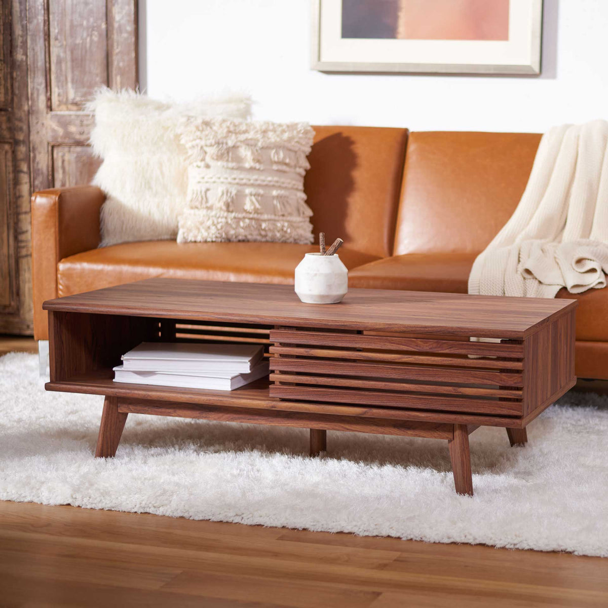 Long, low walnut-finished coffee table combines an open shelf with slatted storage