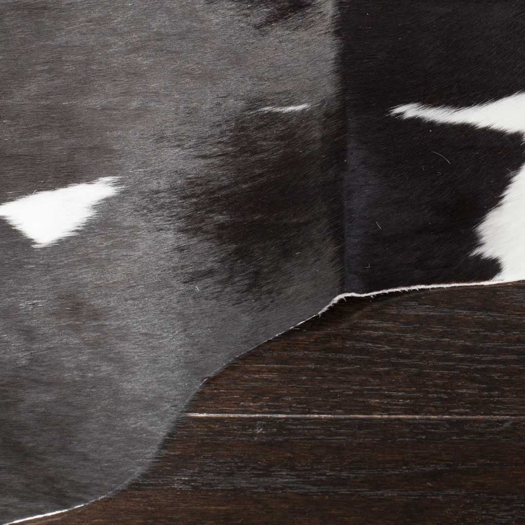 Soft black cowhide hair meets crisp white markings along an organic edge.