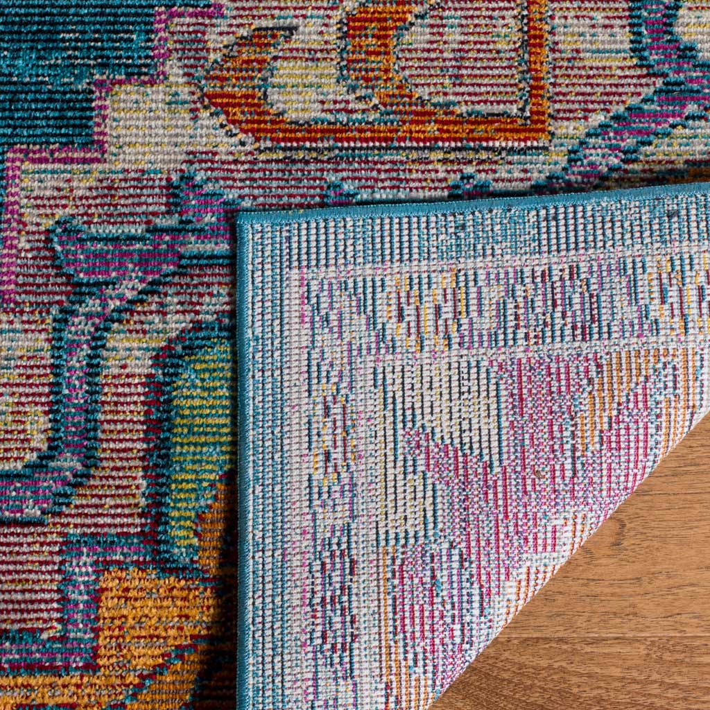 A folded corner reveals the woven backing beneath the rug's vibrant teal and rose design