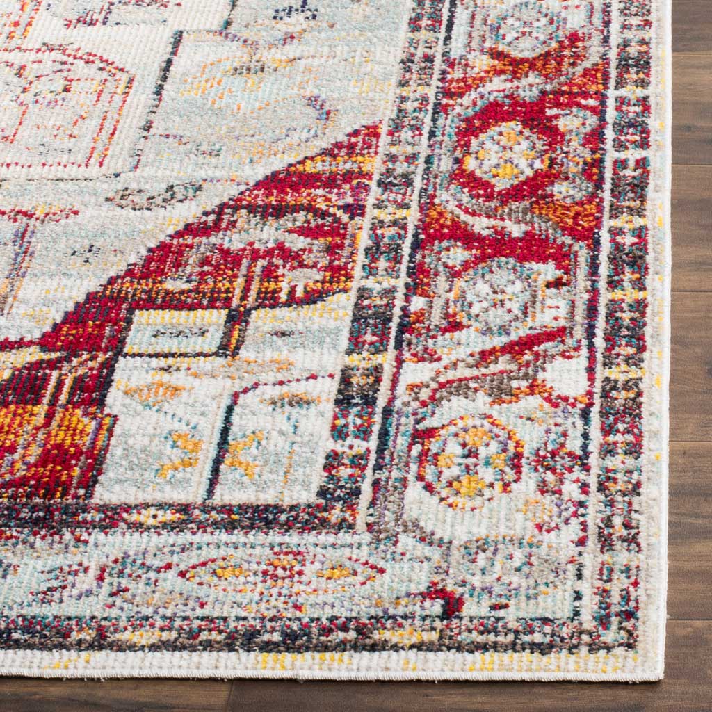 A finished rug corner displays richly textured red floral detailing and pale blue accents