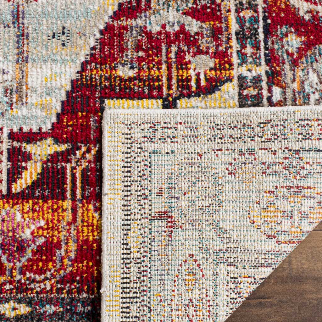 A turned-up rug corner reveals its woven backing beneath colorful red and pale blue patterning