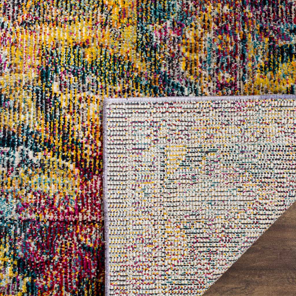 Woven cotton backing contrasts with the navy, gold, and rose pattern on the rug's surface