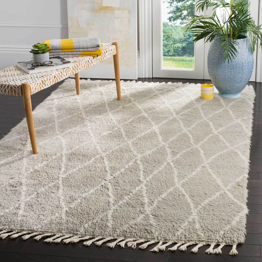 Plush gray wool rug with an ivory diamond trellis and long fringe tassels