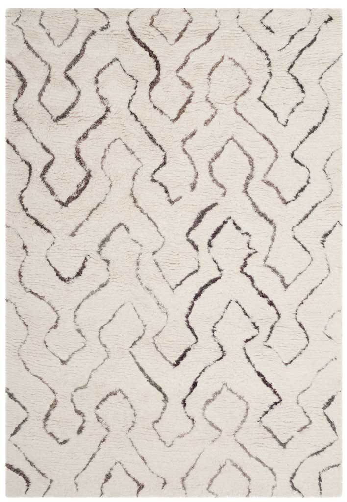An ivory shag rug has an airy geometric pattern of softly shaded lines and cozy, hand-tufted texture.