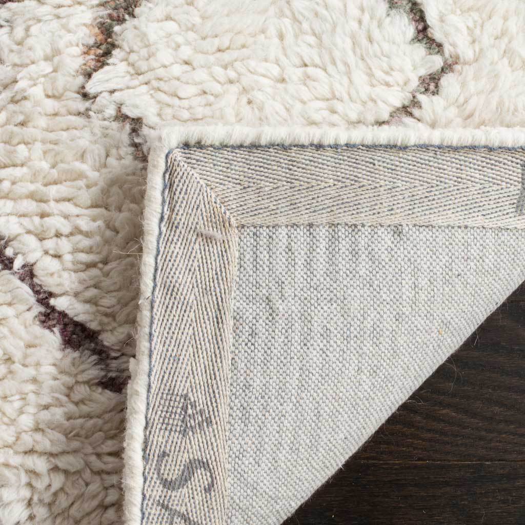 A fold of plush ivory pile reveals the rug's woven fabric backing and finished edge.