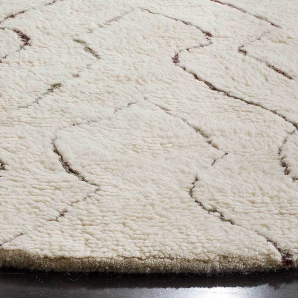 Thick ivory pile and subtle dark lines highlight the soft texture and finished rug edge