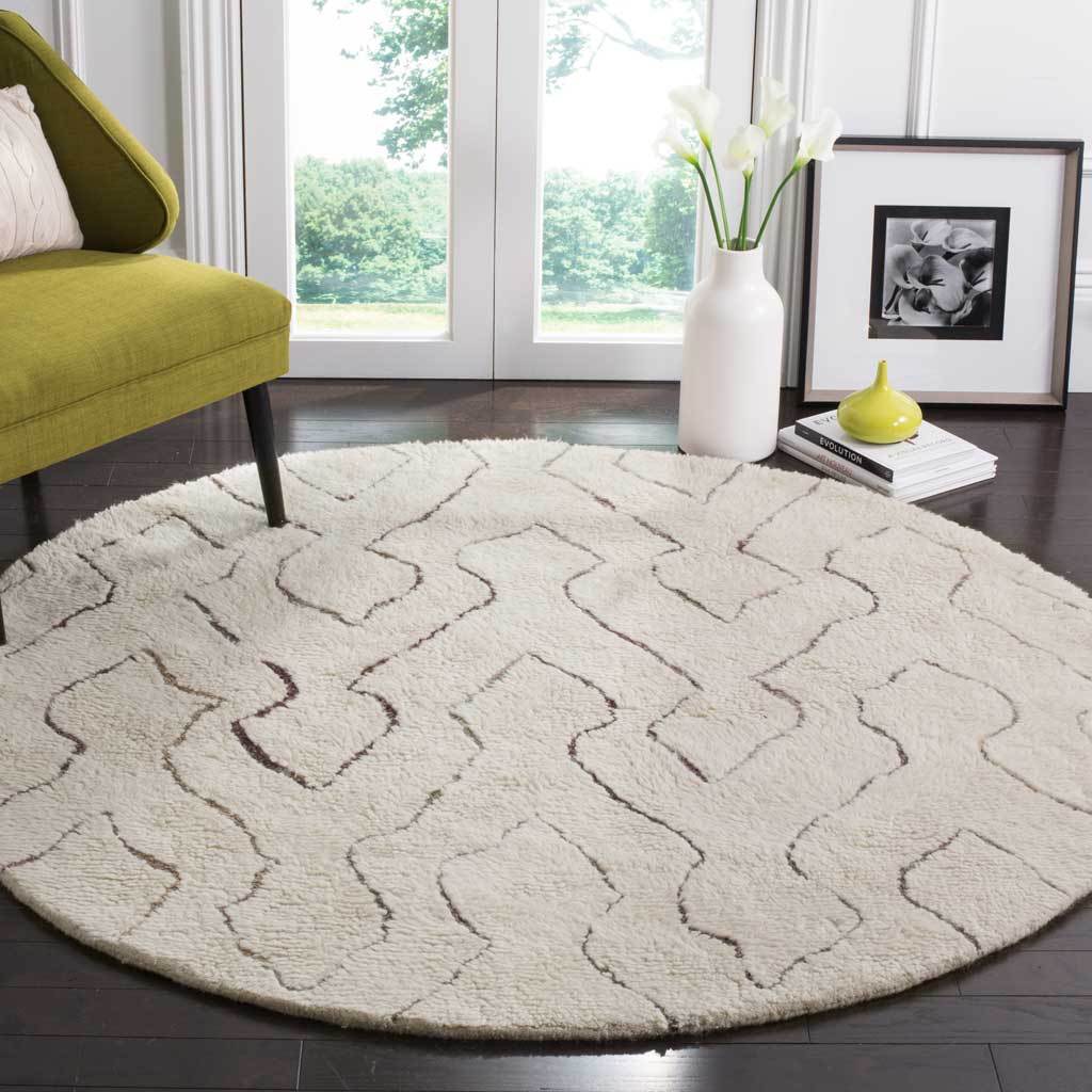 A round ivory rug with plush pile and flowing geometric lines warms a bright living room