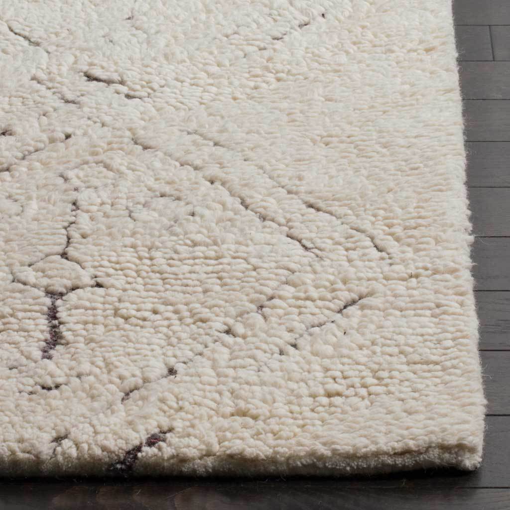 Plush ivory rug corner highlights chunky texture, fine charcoal lines, and a finished edge