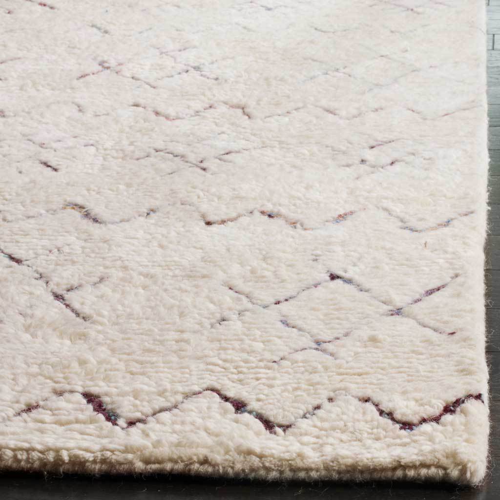 Thick ivory pile and subtle multicolored zigzags meet at the neatly finished rug corner.