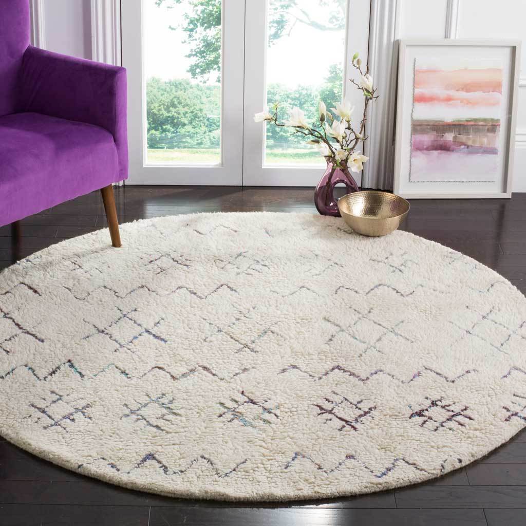 Plush ivory round rug with colorful geometric accents adds warmth and texture to a living room