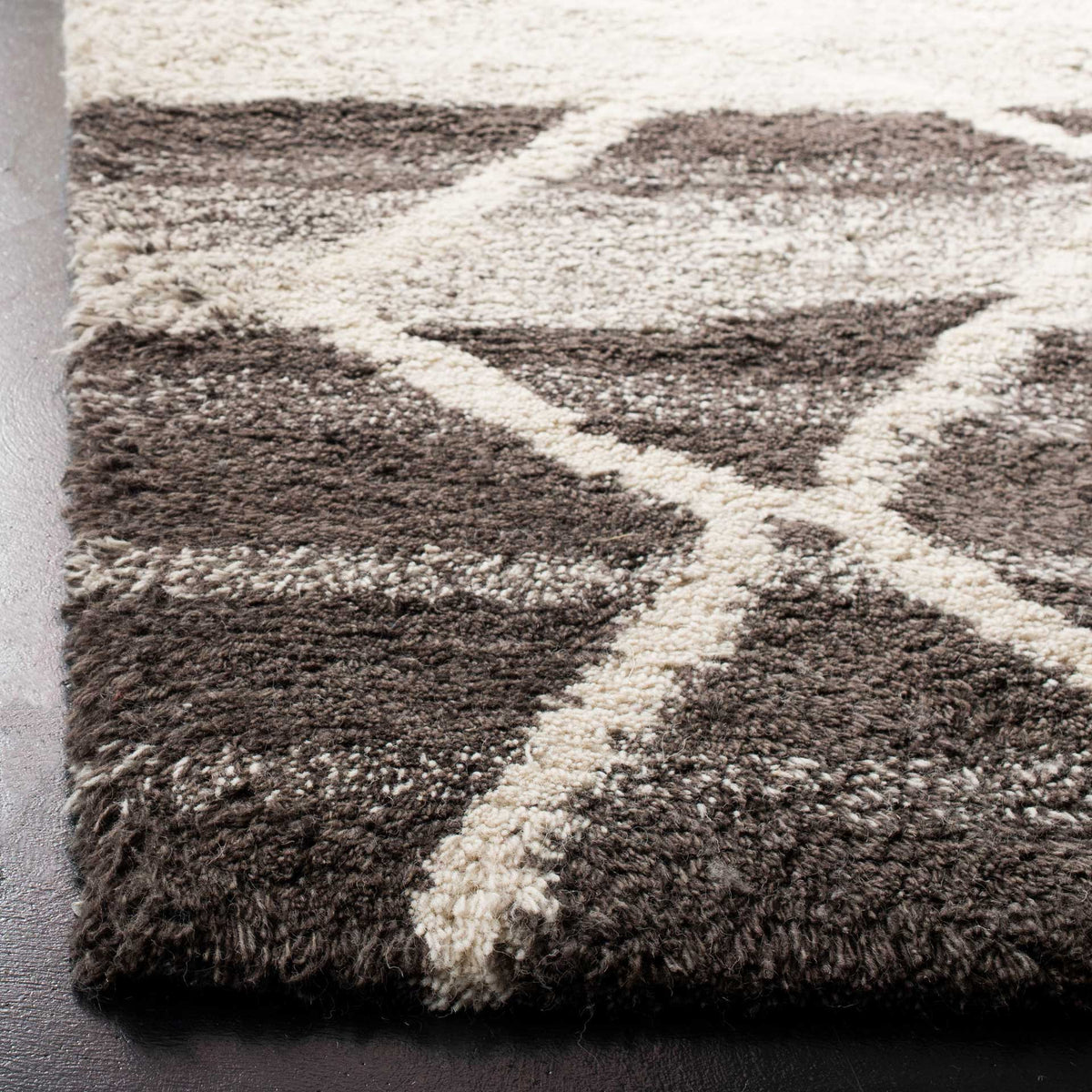 Thick sand-toned wool pile and raised ivory lines add warmth and tactile depth.