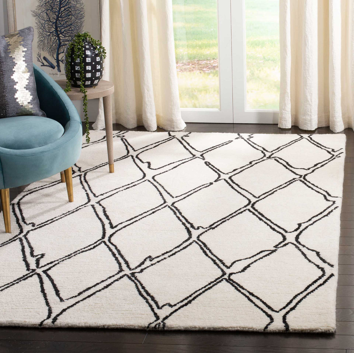 Ivory and black geometric rug adds graphic contrast beside a blue accent chair