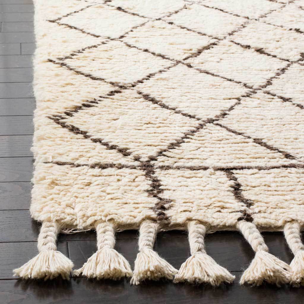 Thick ivory pile and brown diamond lines end in braided, tasseled fringe