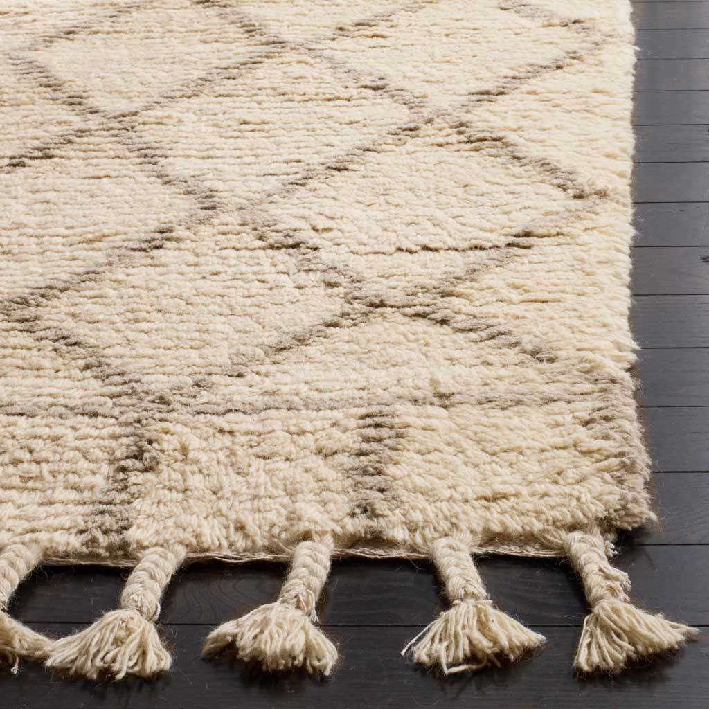 Deep ivory pile, subtle gray lattice lines and braided tassels add inviting texture