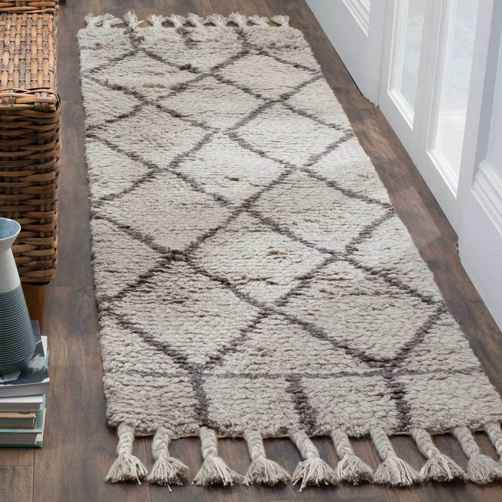 A thick gray runner brings dark diamond lines and soft fringe to a hallway