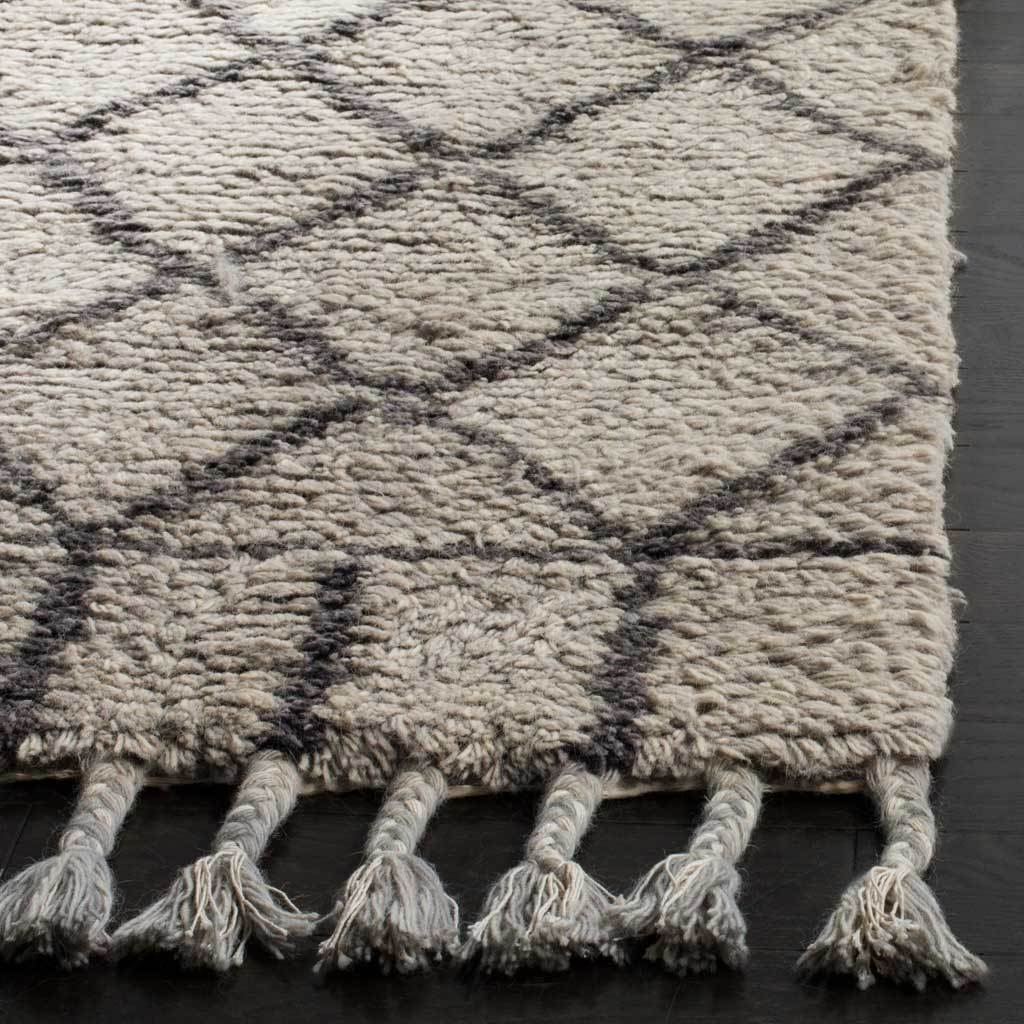 Textured gray pile meets dark gray lattice lines and chunky braided tassels